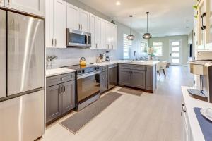 a kitchen with white cabinets and a stainless steel refrigerator at Chic & Spacious 4 Bedroom 3 Full Bathrooms Retreat in West Tampa and Pvt Backyard in Tampa