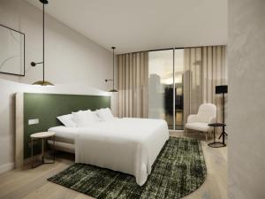 ディーゲムにあるHilton Garden Inn Brussels Airportのベッドルーム(大きな白いベッド1台、椅子付)