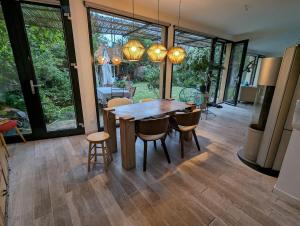 a dining room with a wooden table and chairs at Bright house 10m from Paris in Sèvres +16 photos