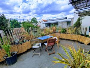 a patio with a table and chairs and a fence at Bright house 10m from Paris in Sèvres