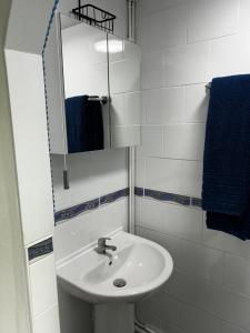 a white bathroom with a sink and a mirror at Ortari@70 in Bishopston