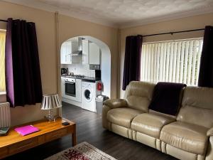 a living room with a couch and a table at Ortari@70 in Bishopston
