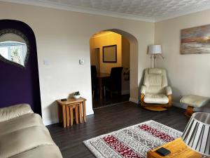 a living room with a couch and a chair at Ortari@70 in Bishopston