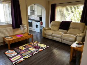 a living room with a couch and a table at Ortari@70 in Bishopston