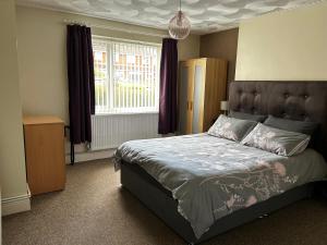 a bedroom with a large bed and a window at Ortari@70 in Bishopston