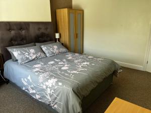 a bedroom with a bed with a gray comforter at Ortari@70 in Bishopston