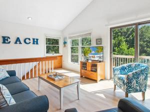 a living room with a couch and a tv at 3041 - The Beach House in Southern Shores +52 photos