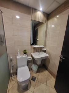 a bathroom with a toilet and a sink at Noha Home in Dubai