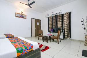 a bedroom with a bed and a desk and a table at ACE-Hotel in Ludhiana