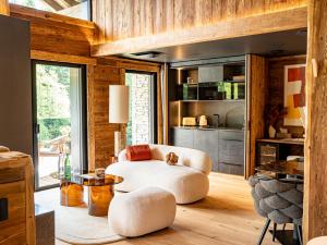 a living room with a white chair and a table at Domaine Les Terres Bleues in Xonrupt-Longemer