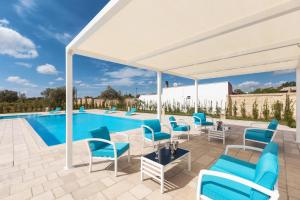 a white pavilion with chairs and a pool at Villa Vincenti by BarbarHouse in Ruffano