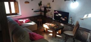 a living room with a couch and a tv at Cabaña Pasiega Lucas in Bustantegua