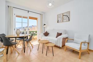 una sala de estar con una mesa y un sofá en Apartamento Mani, en Nerja