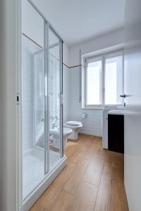 a bathroom with a toilet and a glass shower at My House Apartments in Cremona