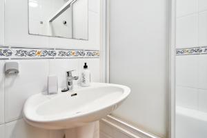 Un baño blanco con lavabo y ducha en Apartamento Mani, en Nerja 15 fotos más