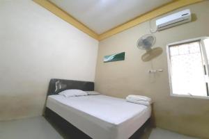 a small room with a bed and a window at OYO Life 2982 Griya Aisyah Residence 2 in Kedurus