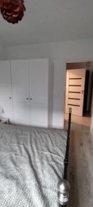 a bedroom with a bed and white cabinets and a door at Meta nad morzem in Pogórze