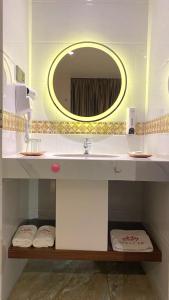 ein Badezimmer mit Waschbecken und Spiegel in der Unterkunft SELECTA HOTEL Medan in Medan