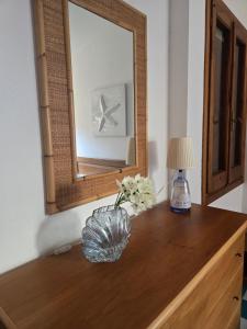 a mirror on top of a wooden dresser with a vase at Golden Dune View in Torre Dei Corsari +22 photos