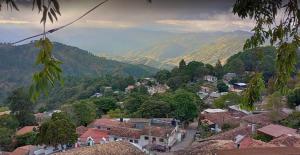 a view of a town with mountains in the background at Valle de Ángeles Entre Hamacas y Fogatas in Valle de Ángeles