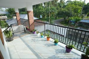 a balcony with potted plants and a railing at Wayanadan Huts Homestay in Sultan Bathery