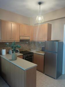 a kitchen with wooden cabinets and a blue refrigerator at Mola Breeze in Mola Kalyva +3 photos