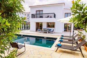 a villa with a swimming pool and a house at Villa Cloxania Coral in Peyia