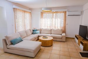 una sala de estar con un sofá y una mesa en Villa Cloxania Coral, en Peyia