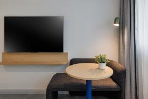 a room with a table and a chair and a tv at Quest at Sydney Olympic Park in Sydney +45 photos