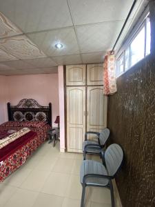 a bedroom with a bed and chairs in it at 2 Bedrooms innara Rooms Bhurban A1 in Bhurban