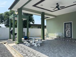 a pavilion with a table and benches on a patio at Homestay Rakyat Dungun in Dungun