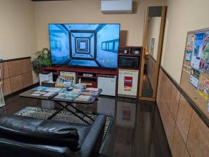 a living room with a large television and a table at ホテル ツインビー in Yabase