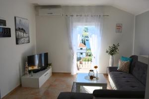 a living room with a couch and a tv at Maris Rogoznica in Rogoznica