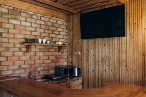 a kitchen with a microwave and a television on a brick wall at Holiday Home Atmatas in Sabile