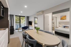 a hotel room with a table and a bed at Quest at Sydney Olympic Park in Sydney