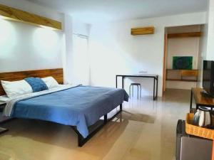 a bedroom with a blue bed and a table at Orchid Bed and Breakfast in Galicias