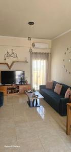 a living room with a blue couch and a tv at Frosos house in Kefalos