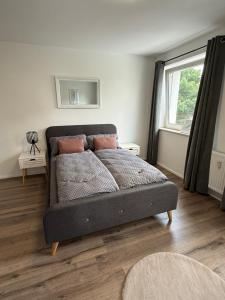 ein Schlafzimmer mit einem Bett in einem Zimmer mit einem Fenster in der Unterkunft Moderne Ferienwohnung im Herzen von Rheinbach- zentral, gemütlich, gut ausgestattet in Rheinbach