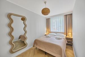 斯维诺乌伊希切Apartamenty Nautilus 103的带床和镜子的卧室 更多6张照片