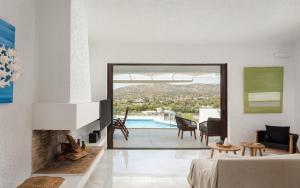 a bedroom with a fireplace and a living room with a view at Sounio Sea Breeze Villa in Sounio +42 photos