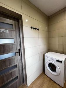 a washing machine in a room with a door at Hostel S8 in Guty Bujno +8 photos