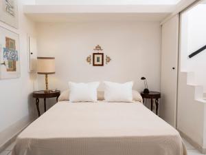 a white bedroom with a large bed with white sheets at La Dimora del Re in Erice