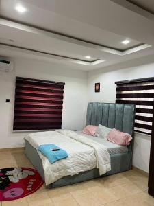 a bedroom with a large bed with pink and blue towels on it at Reyna apartment in Lekki +2 photos