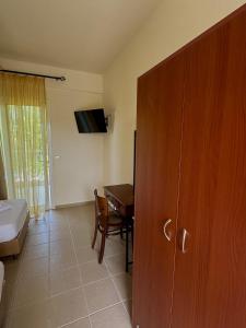 ein Zimmer mit einem Schlafzimmer mit Schreibtisch und Tisch in der Unterkunft Dafnes Rooms in Fourka