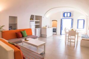 a living room with a couch and a table at Gemini Cave Florina in Oia +27 photos