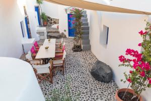 a dining room with a table and chairs and flowers at Gemini Cave Florina in Oia