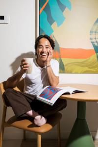 a woman sitting at a table with a cup of coffee at lyf Bondi Junction Sydney in Sydney