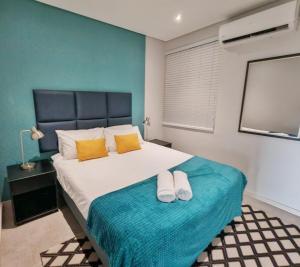una camera da letto con un letto grande con due asciugamani sopra di 707 2six2 Florida Rd- corporate 1 bedroom a Durban Altre 26 foto