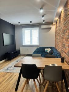 a living room with a couch and a table at Apartament Pod Filarami in Zielona Góra +6 photos