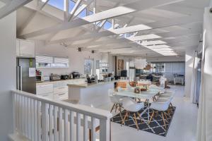 a kitchen and dining room with a table and chairs at Nordic Family Beach House in Bettyʼs Bay